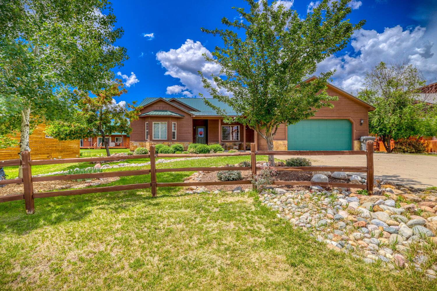 A home with a fence and grass in the front yard.