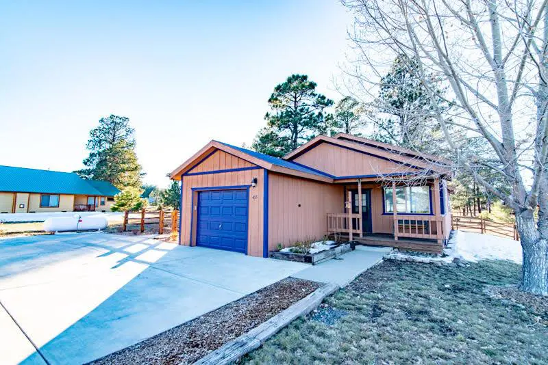 A blue house with a garage in front of it.