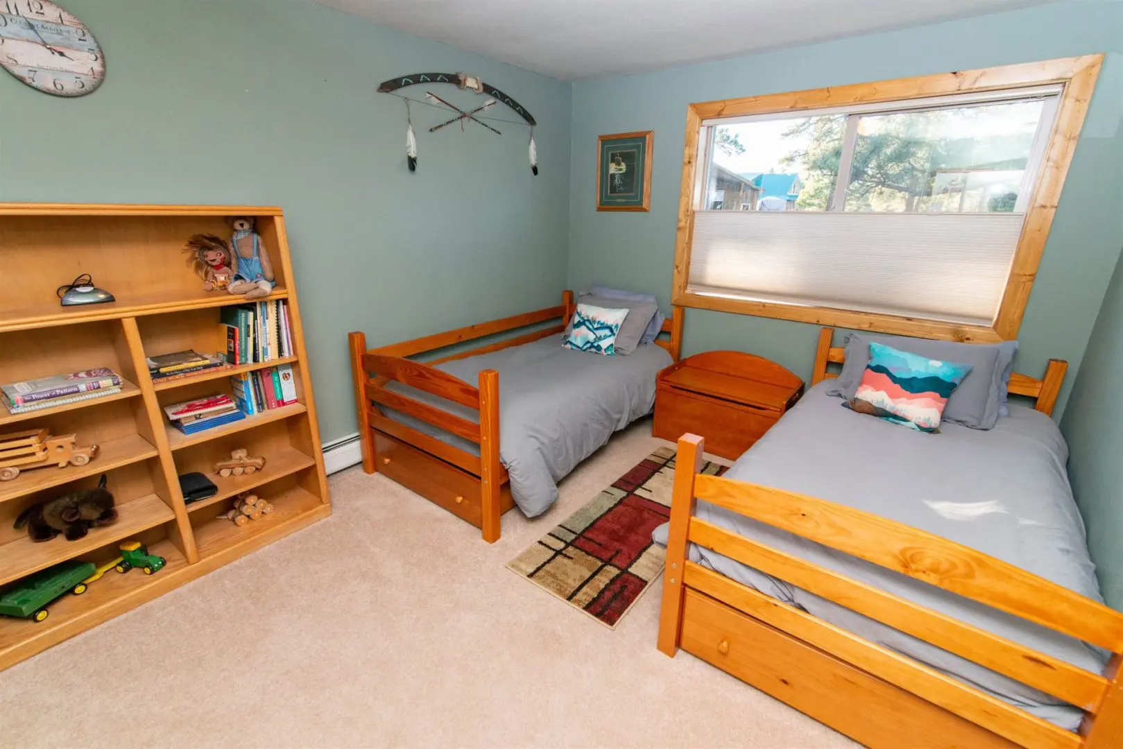 A small bedroom with two bunk beds and a bookcase.