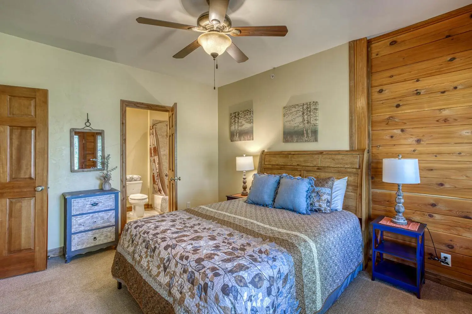 A bedroom with wood paneling and a ceiling fan.