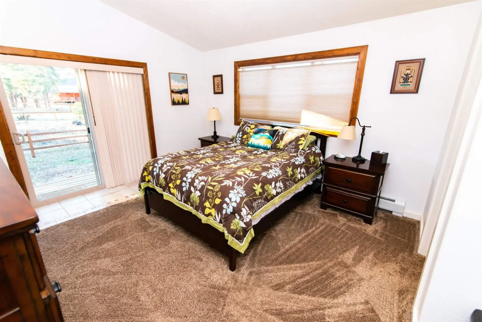 A bedroom with a bed and a sliding glass door.