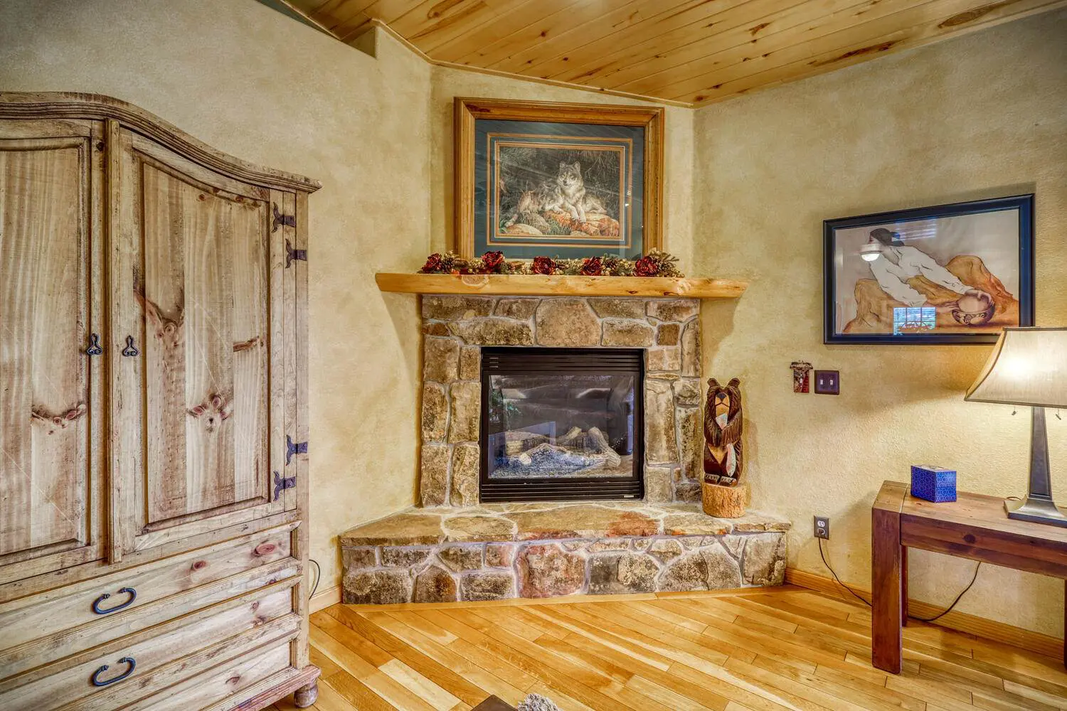 A bedroom with a fireplace and a dresser.