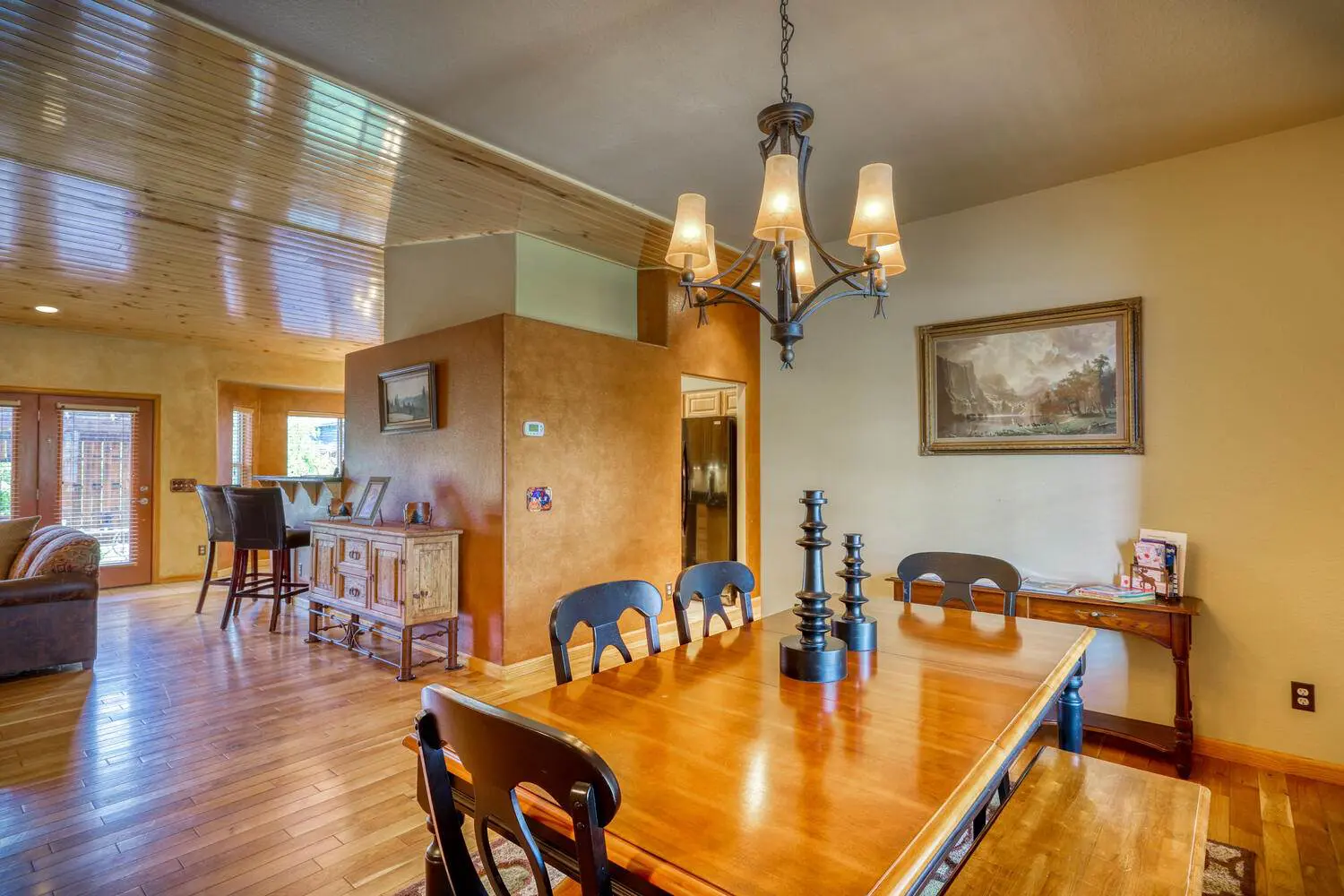 A dining room with hardwood floors and a wooden table.