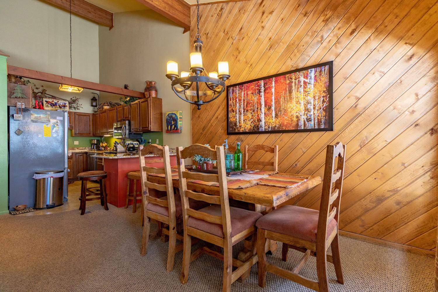 A kitchen with wood paneling and a dining table.