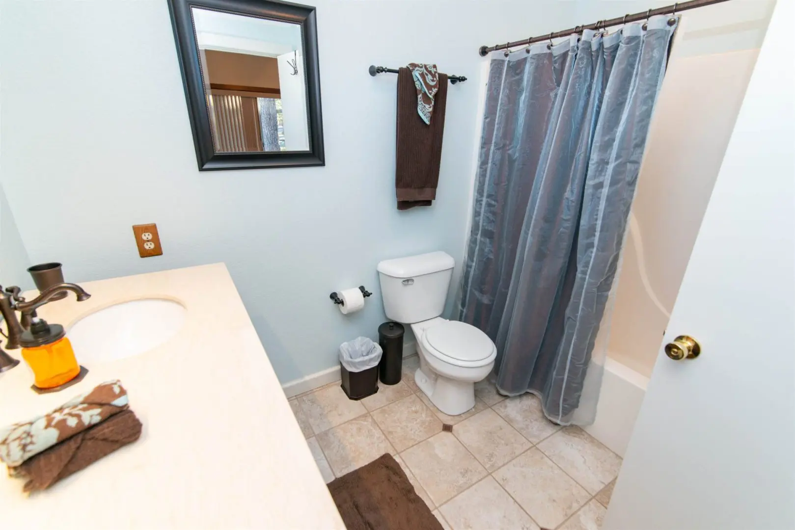 A bathroom with a toilet and a shower curtain.