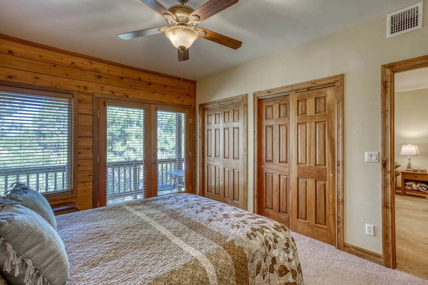 A bedroom with wood floors and a ceiling fan.