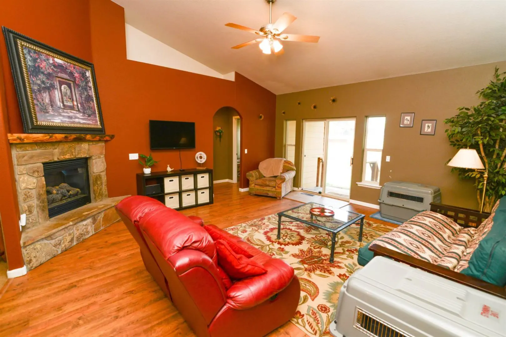 A living room with red furniture and a fireplace.