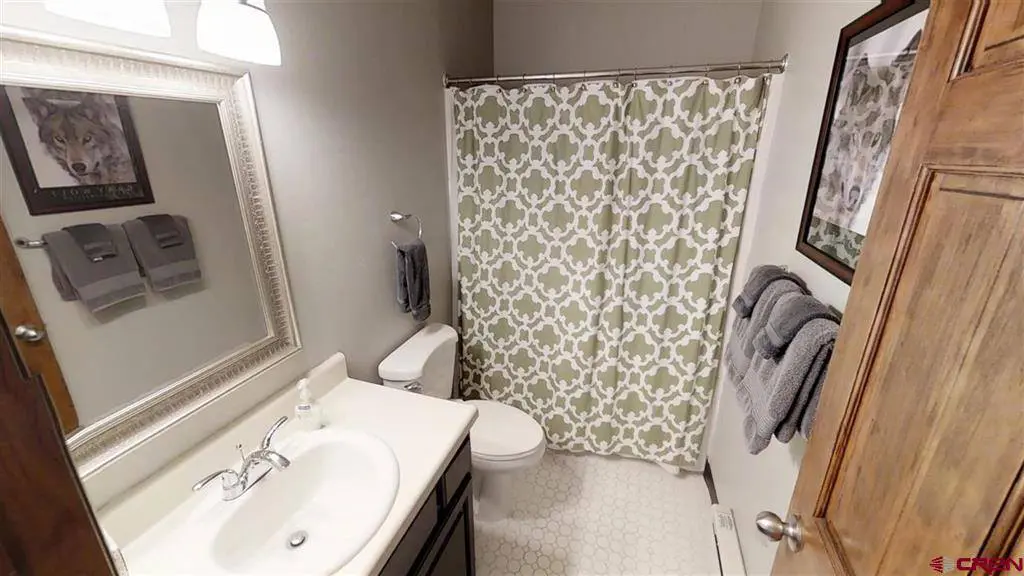 A bathroom with a shower curtain and sink.