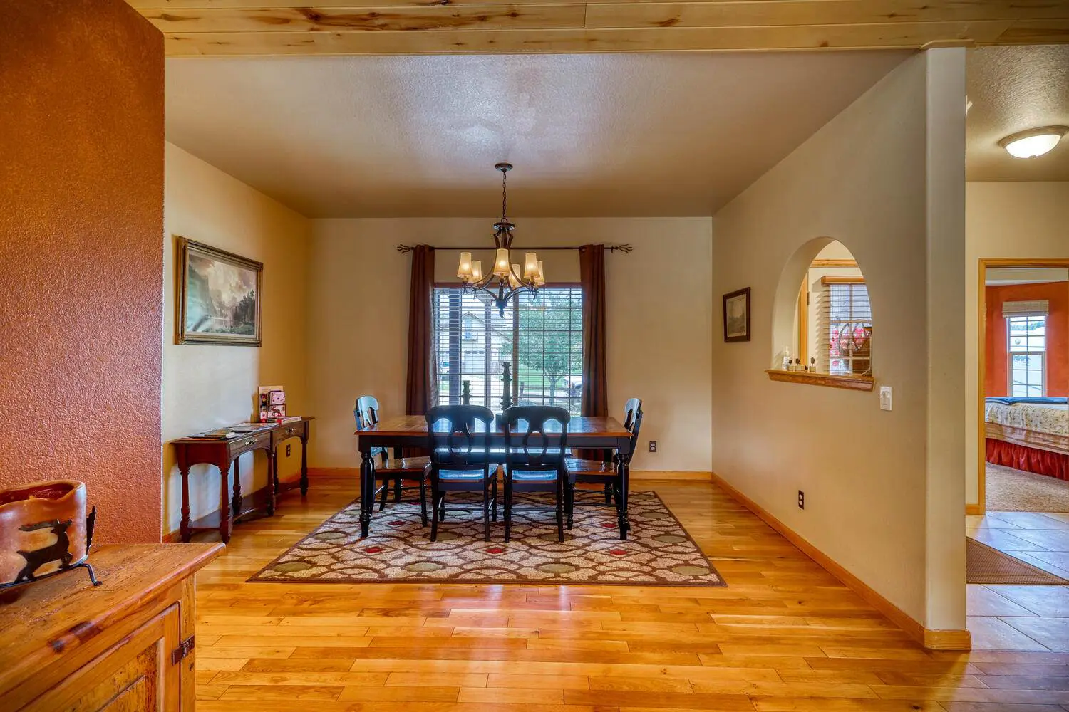 A dining room with hardwood floors and a dining table.