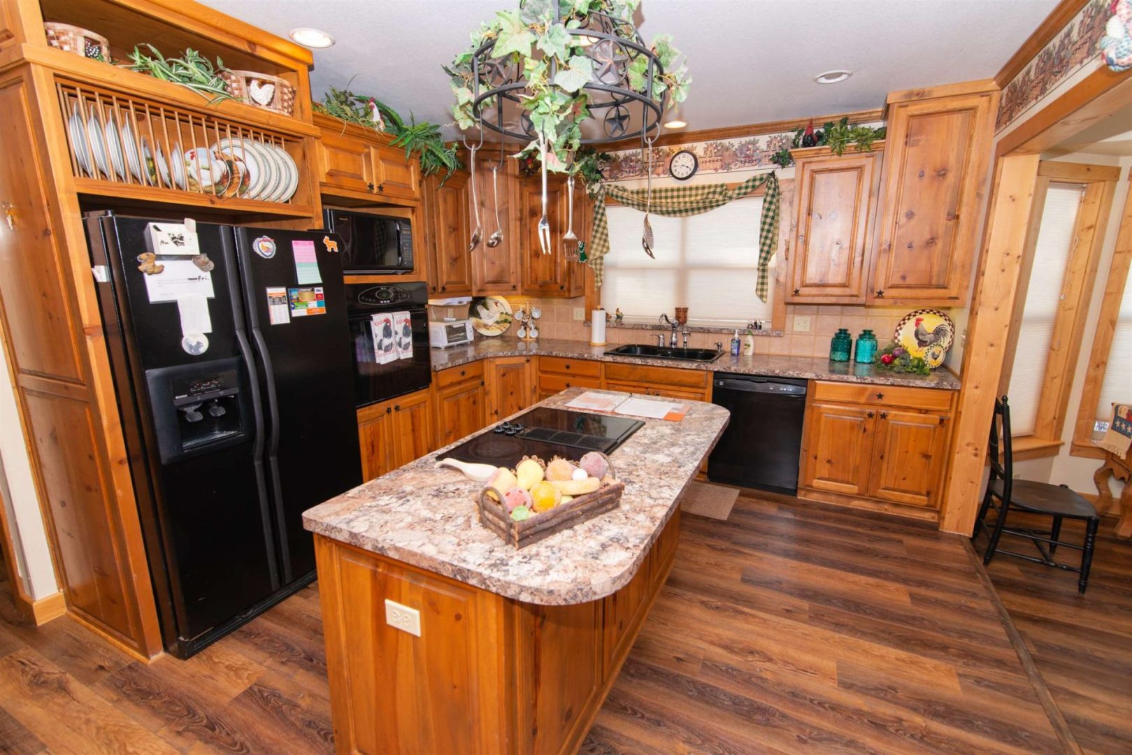 Room with a kitchen along with a fridge