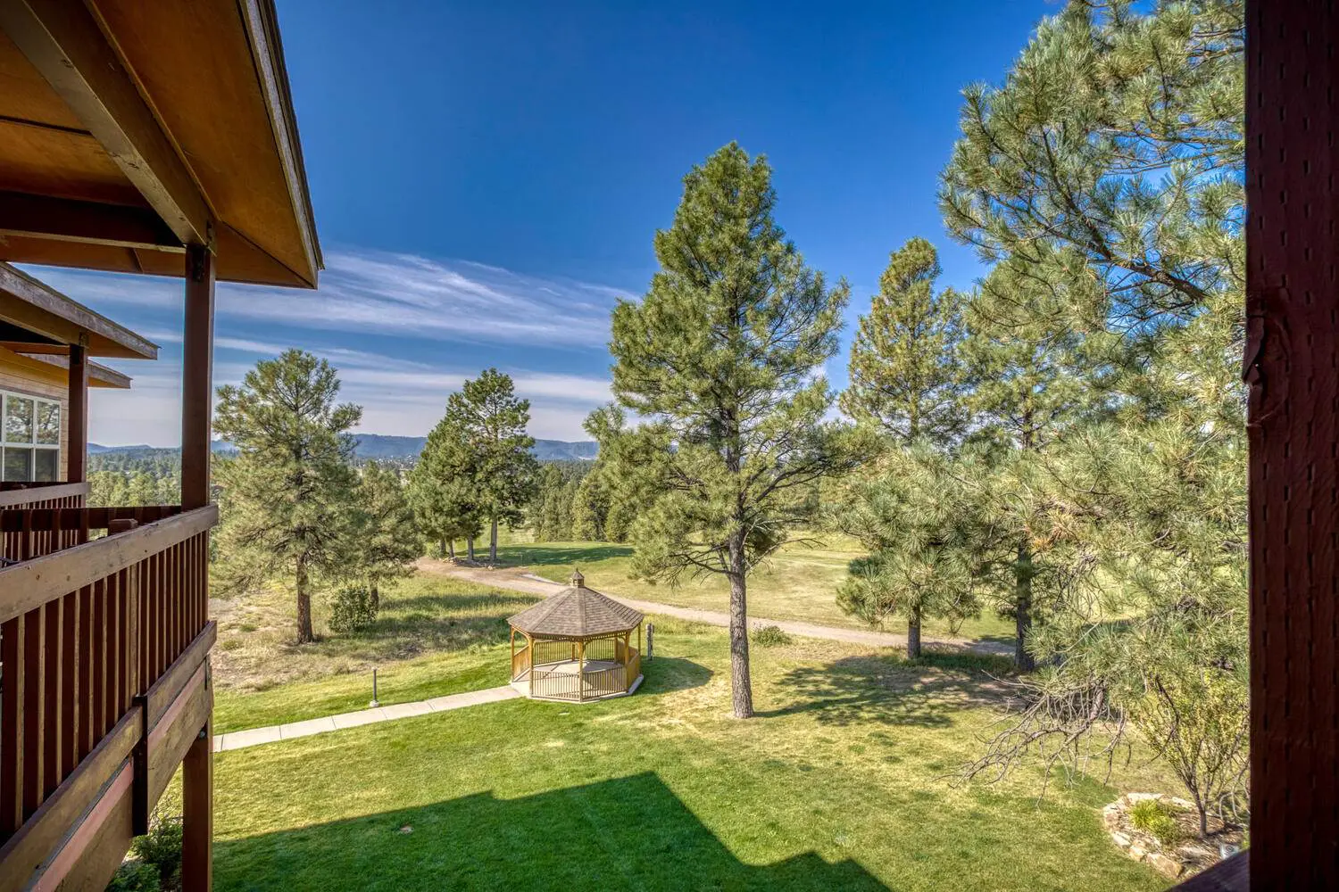 A view from the balcony of a cabin overlooking a golf course.