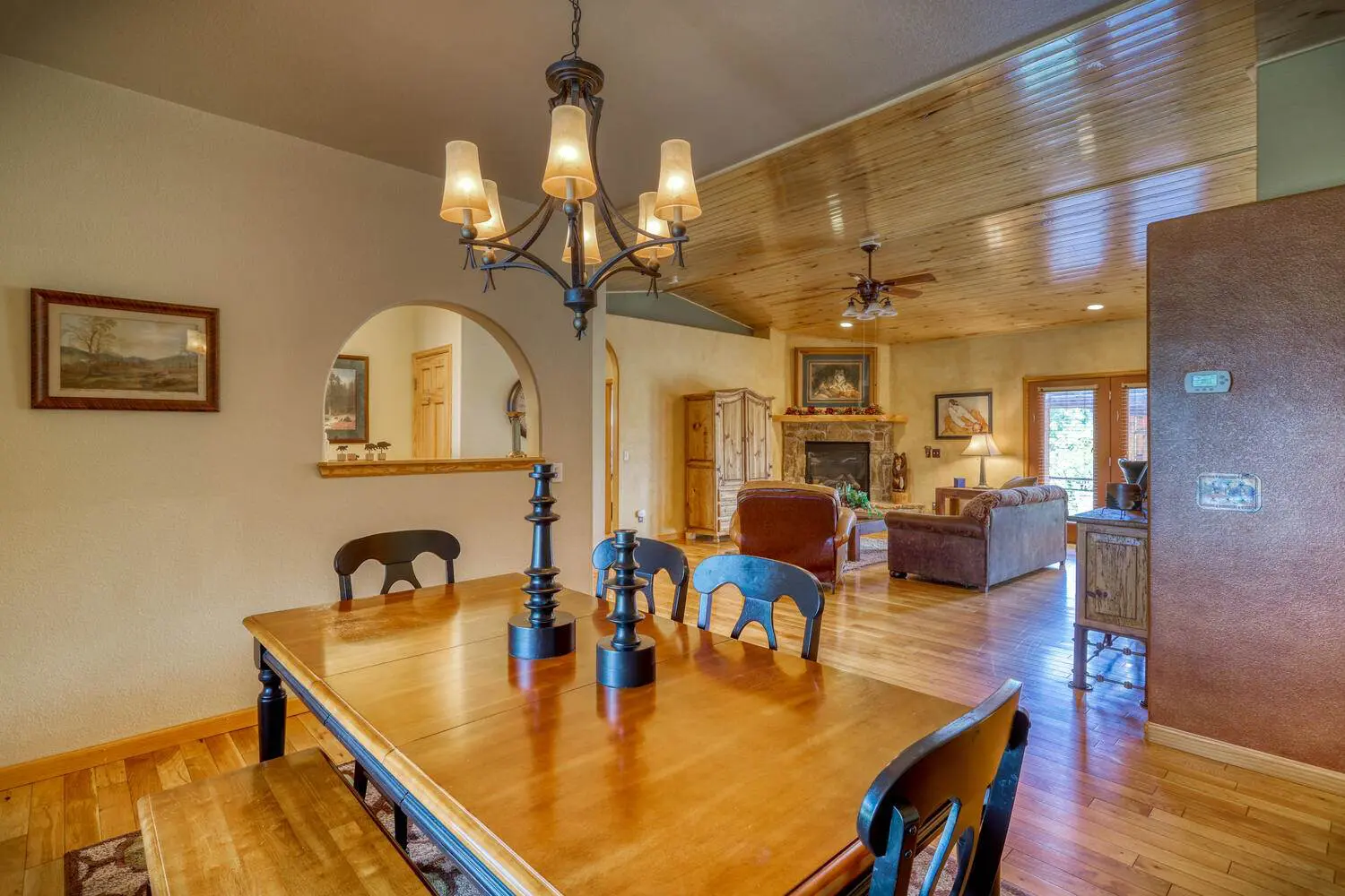 A dining room with wood floors and a fireplace.