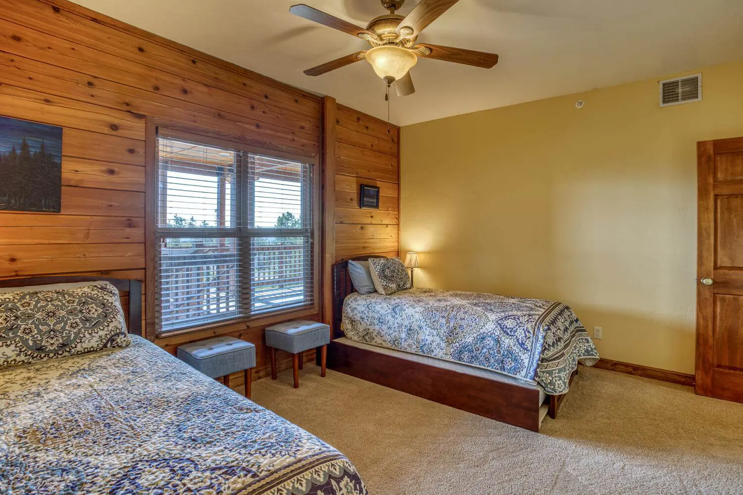 A bedroom with two beds and a ceiling fan.