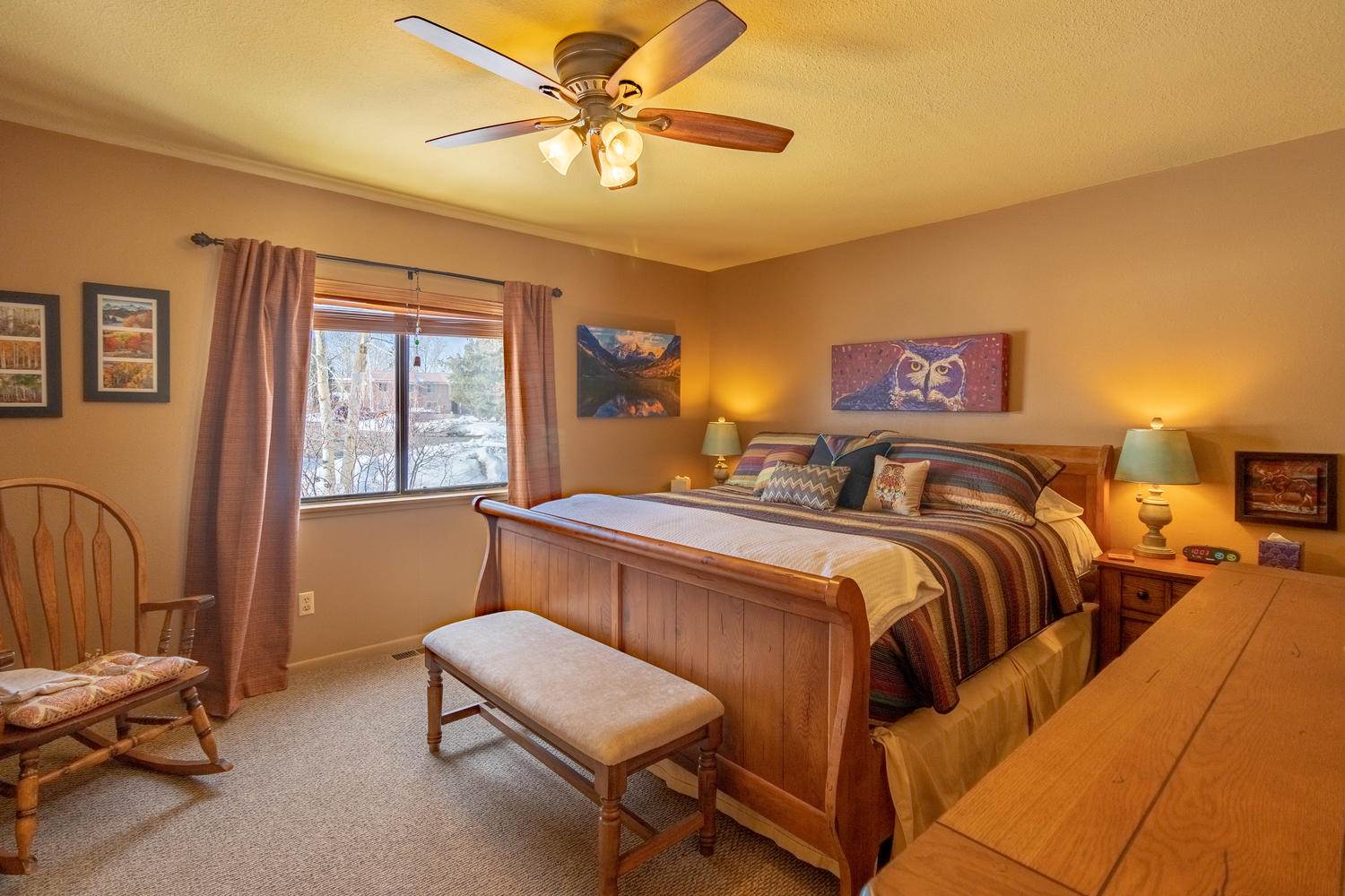 A bedroom with a bed and a rocking chair.