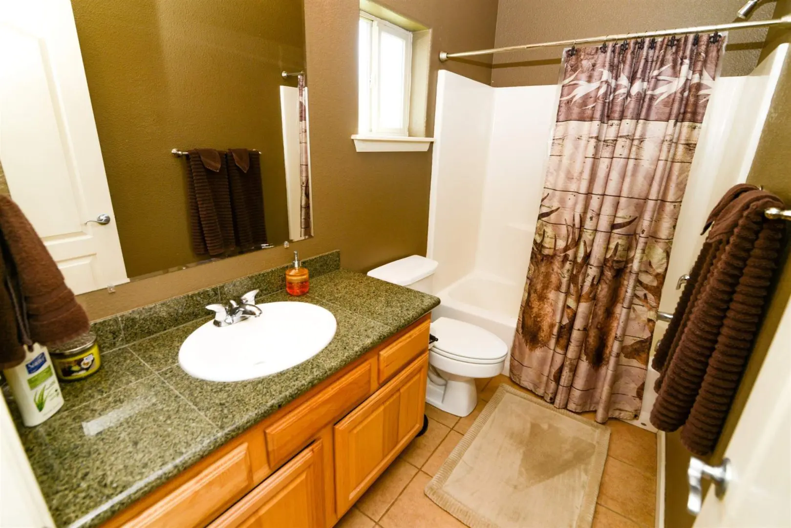 A bathroom with a brown shower curtain.