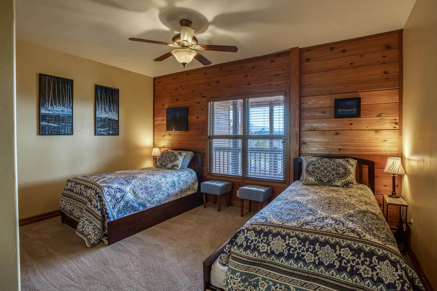 A bedroom with two beds and a ceiling fan.