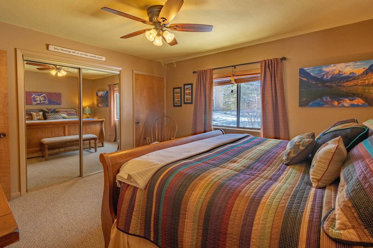 A bedroom with a large bed and a ceiling fan.