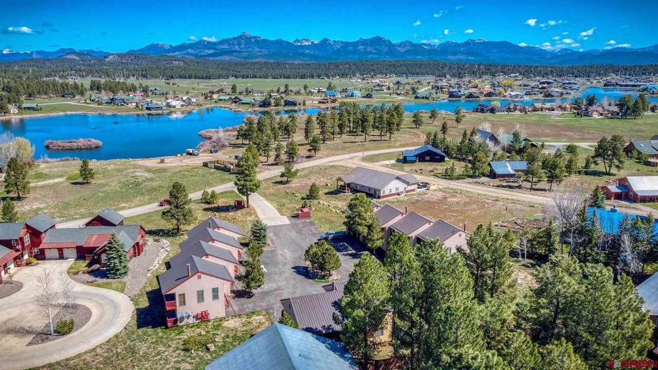 An aerial view of a lake and houses in the mountains.