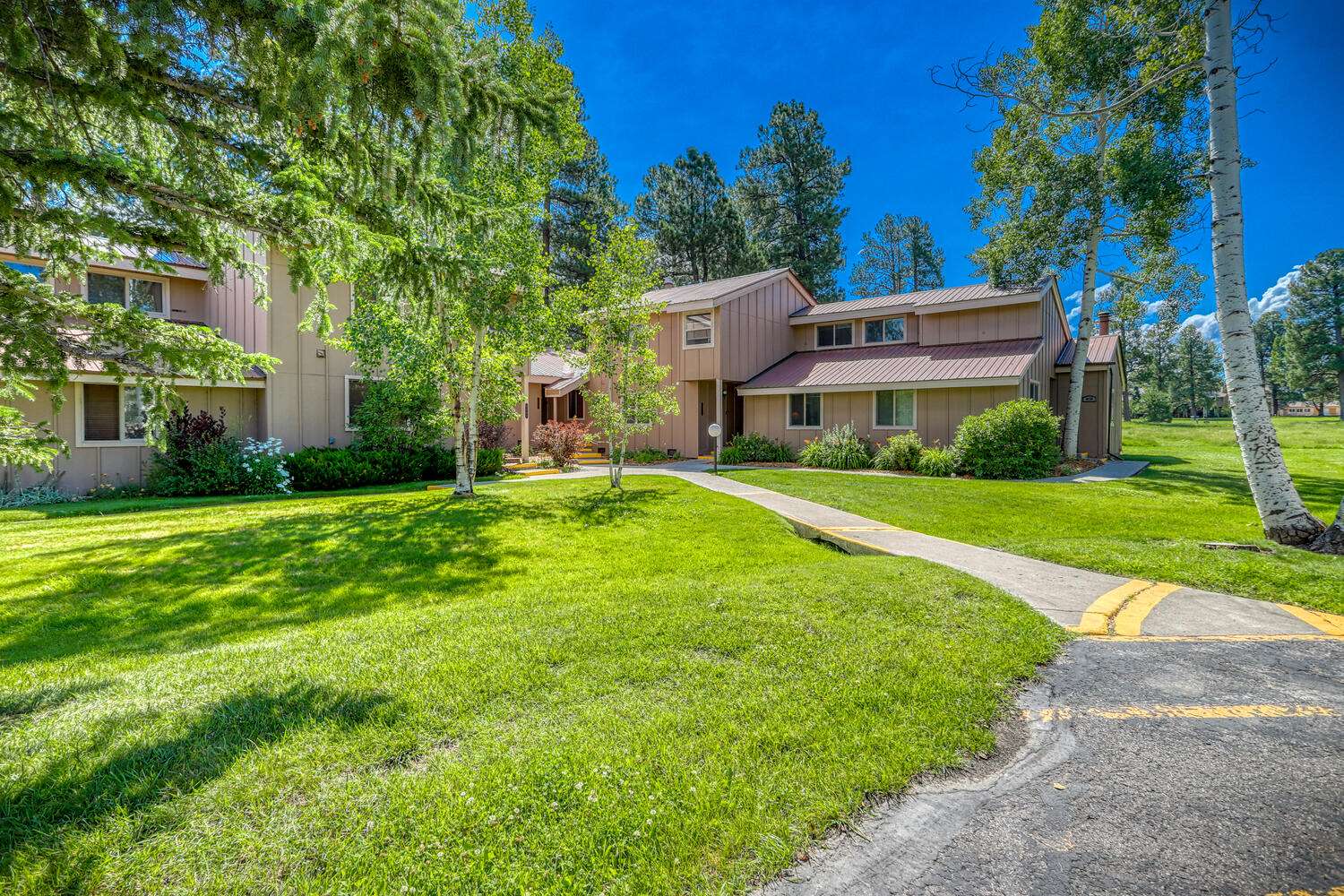 An apartment complex with grass and trees in the background.