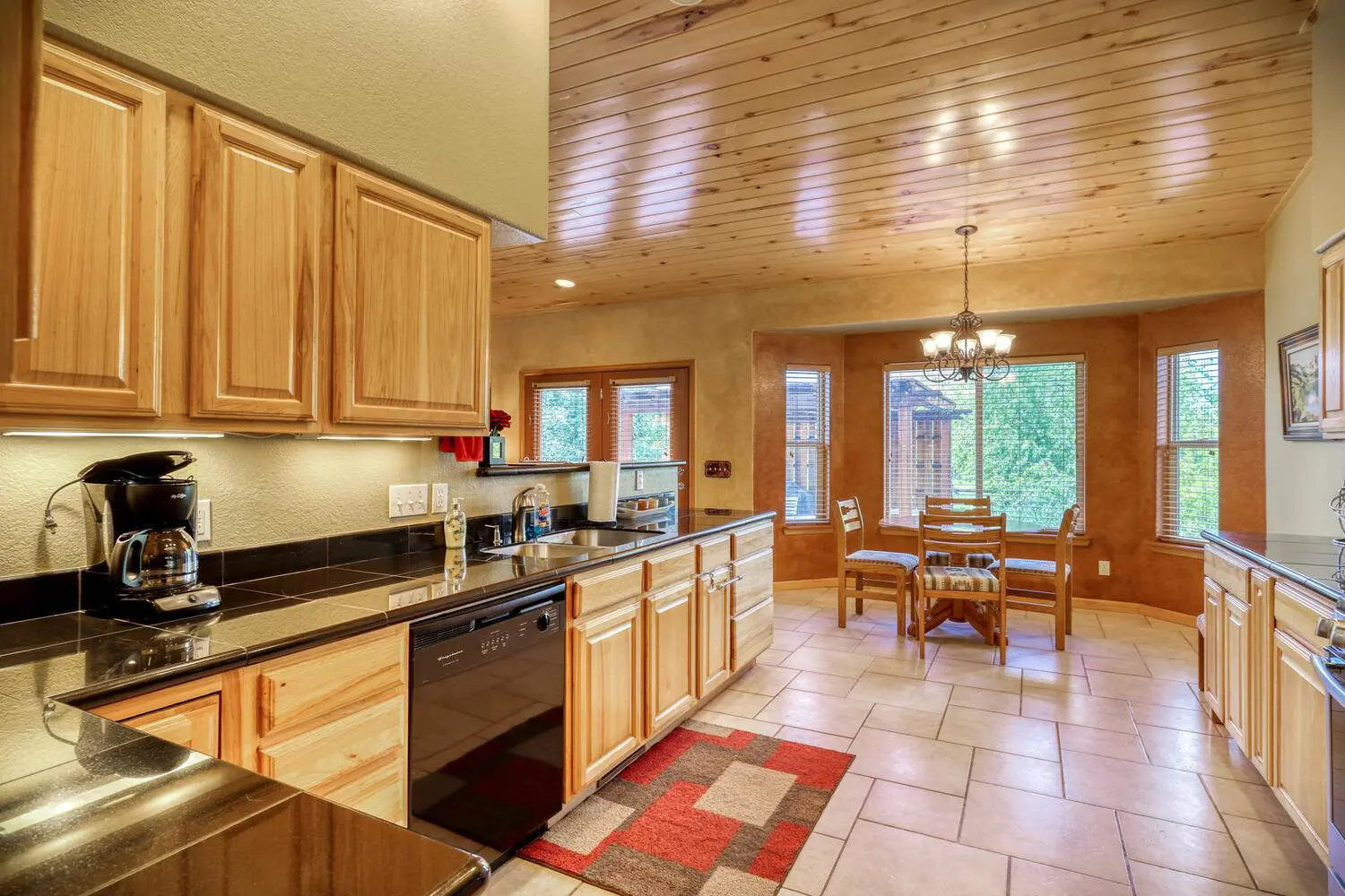 A kitchen with wood cabinets and granite counter tops.