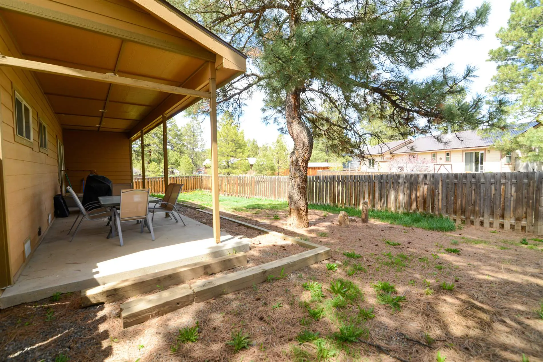 A small backyard with a table and chairs.