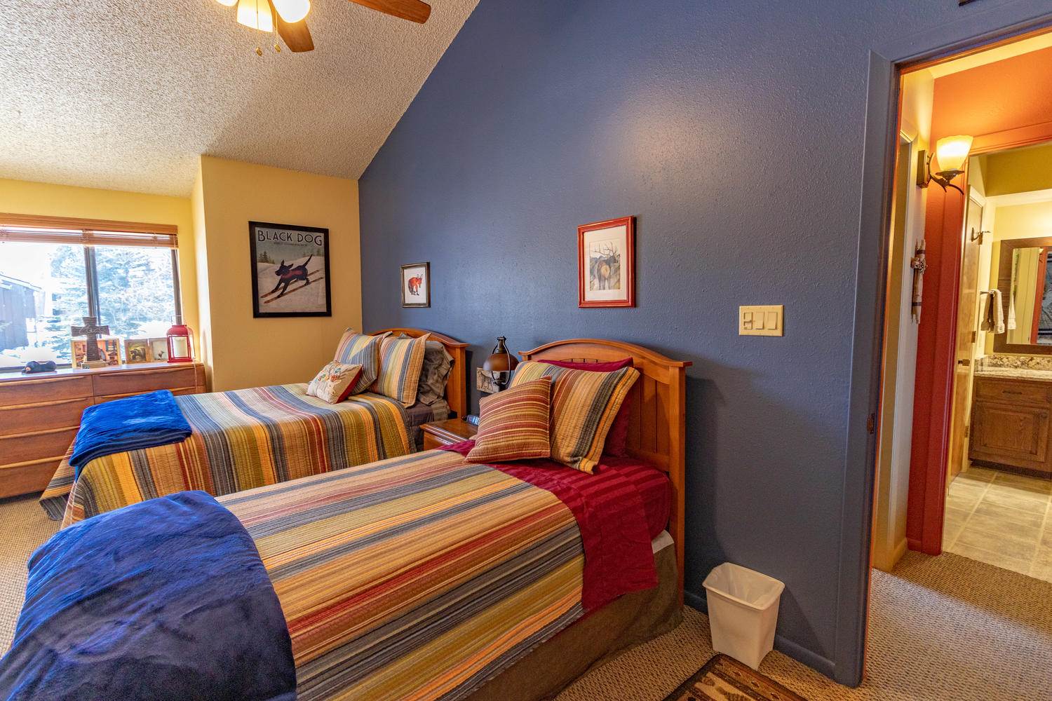 A bedroom with two beds and a ceiling fan.