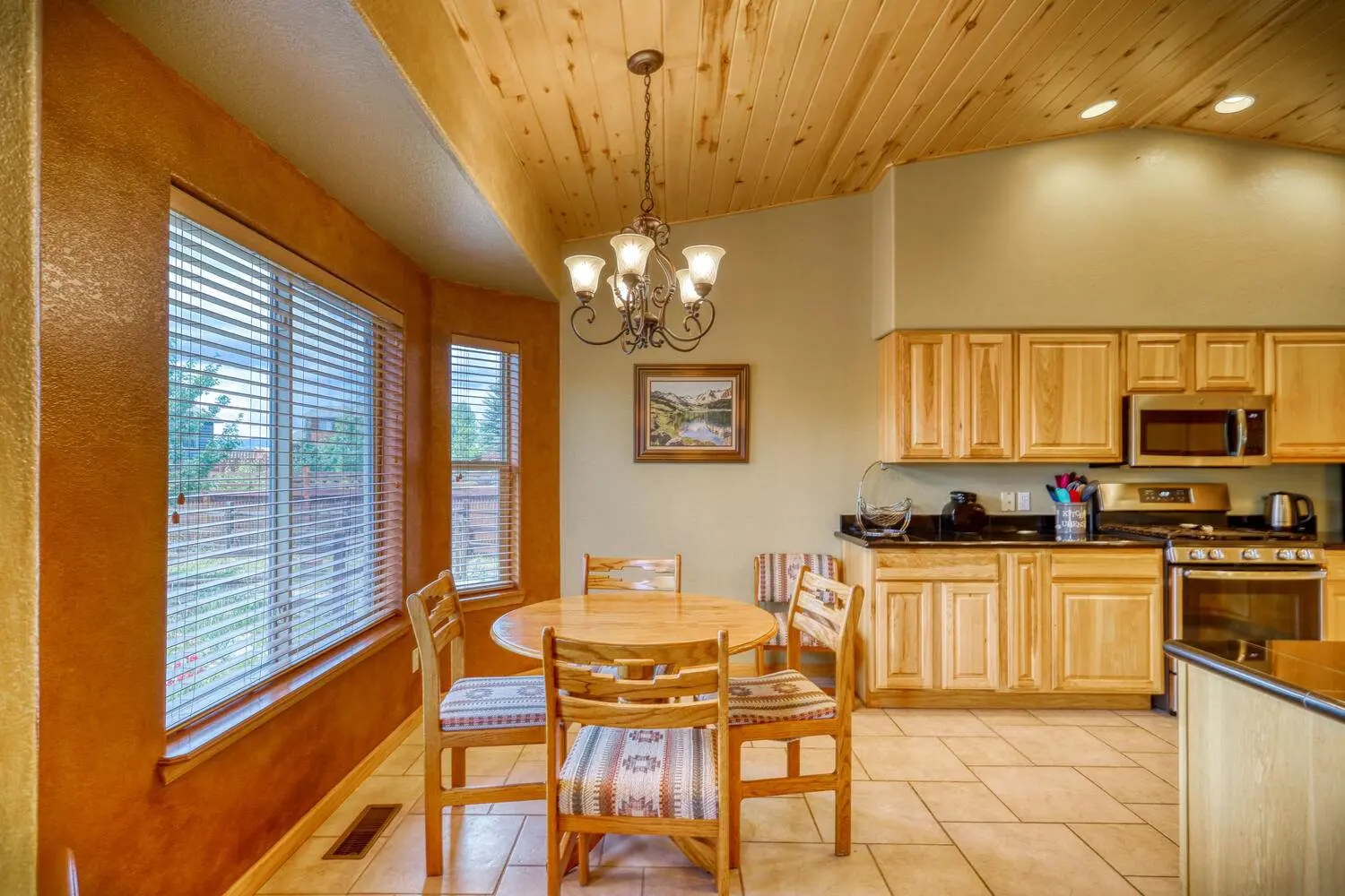 A kitchen with wood cabinets and a table and chairs.