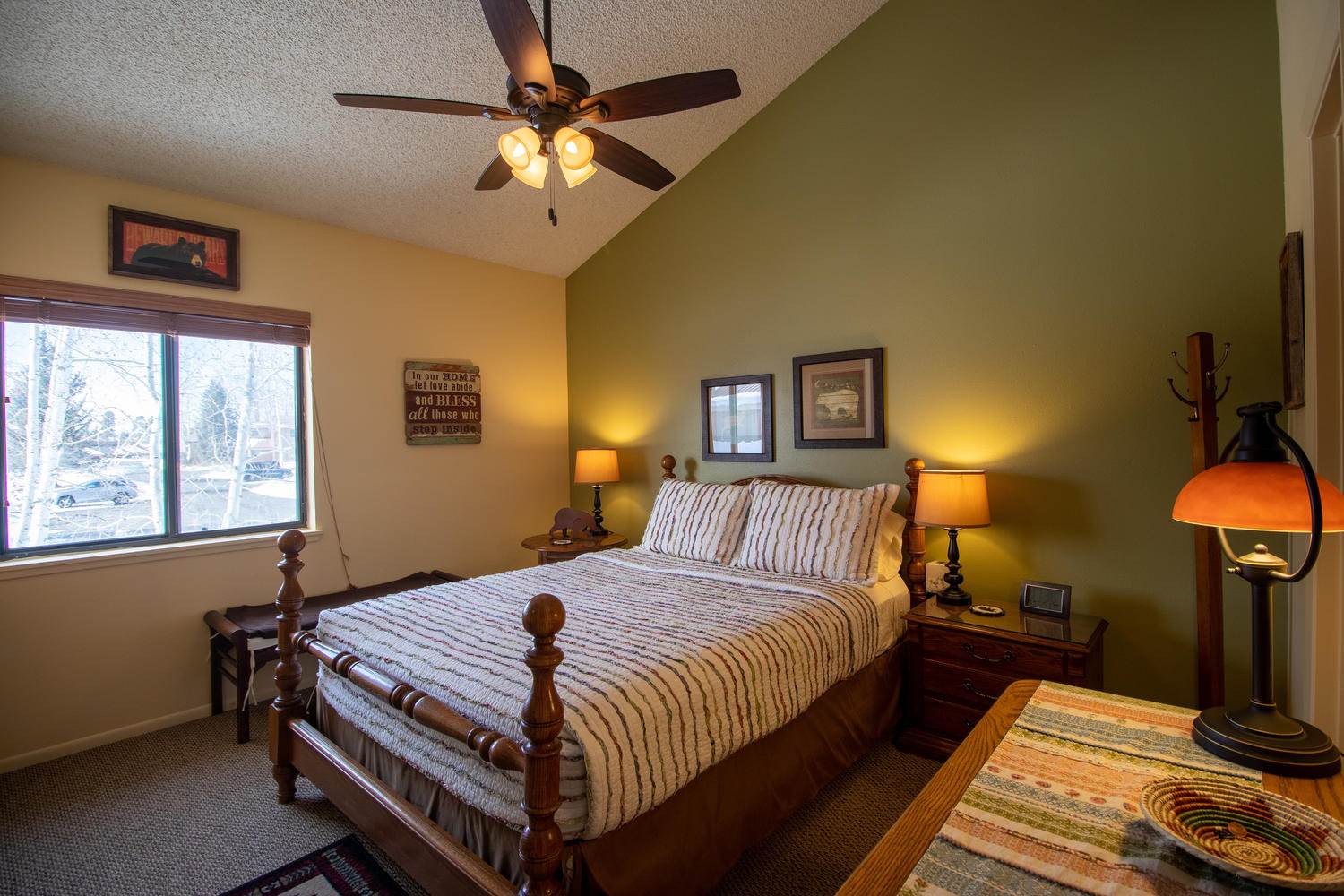 A bedroom with a bed and a ceiling fan.