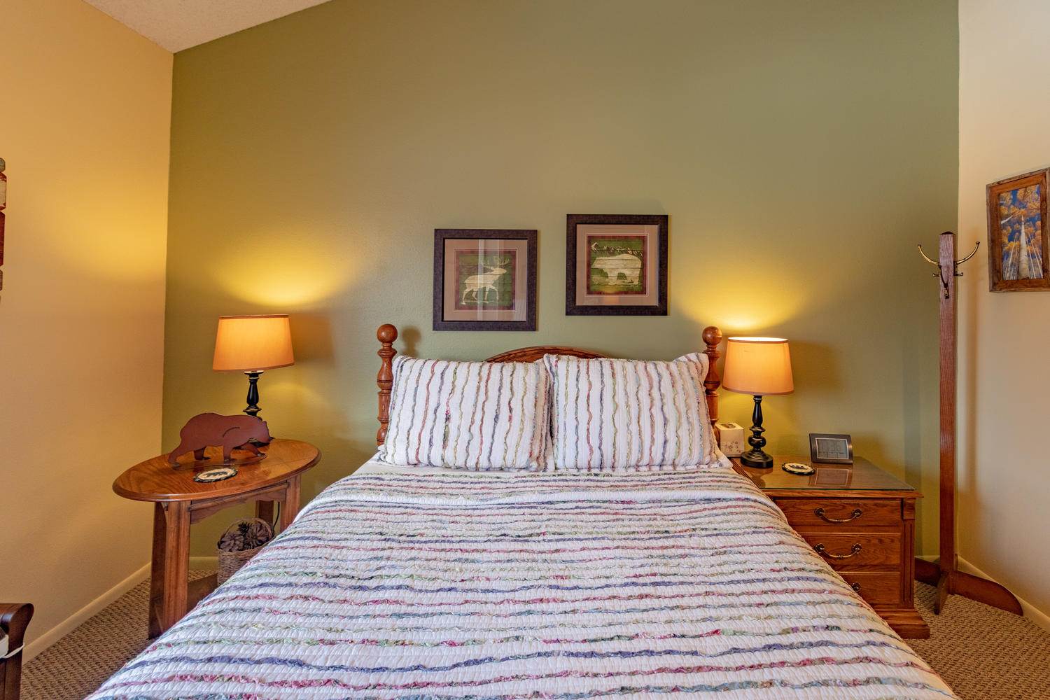 A bedroom with green walls and a bed.