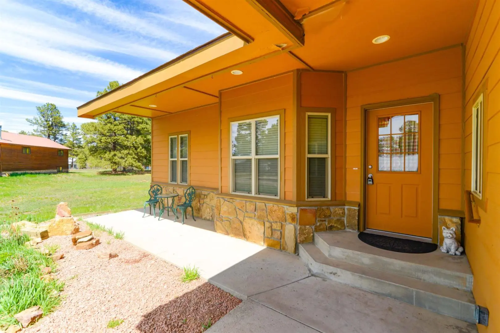 The front porch of a home with a yellow door.