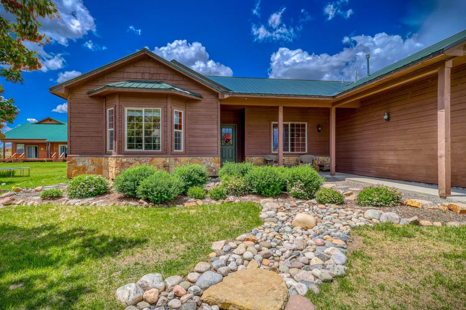 A home with rocks and grass in front of it.