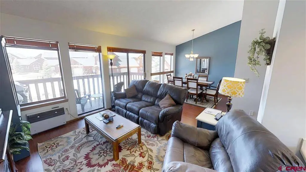 A living room with couches and a balcony.