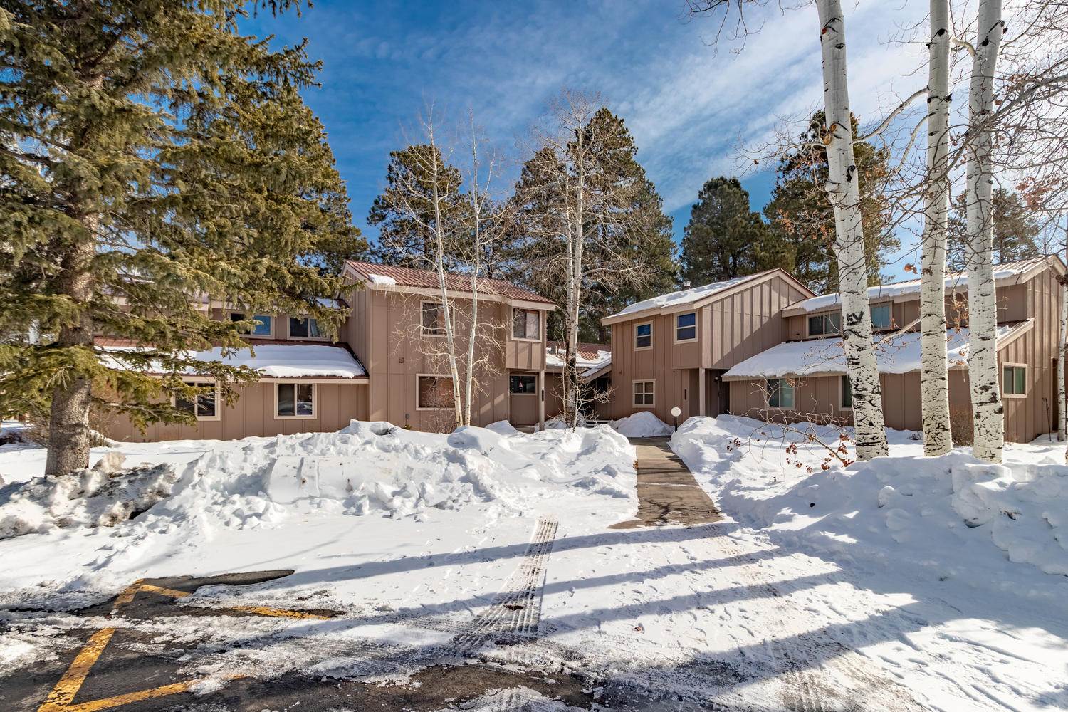 An apartment complex in the winter with snow on the ground.