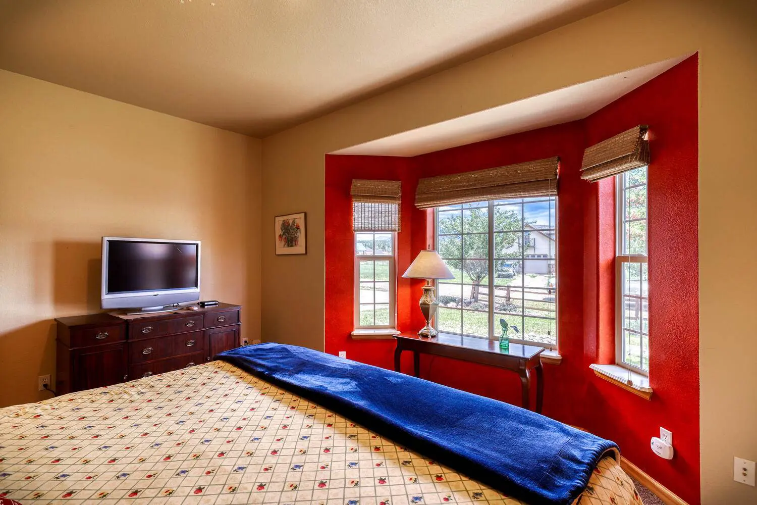 A bedroom with red walls and a tv.