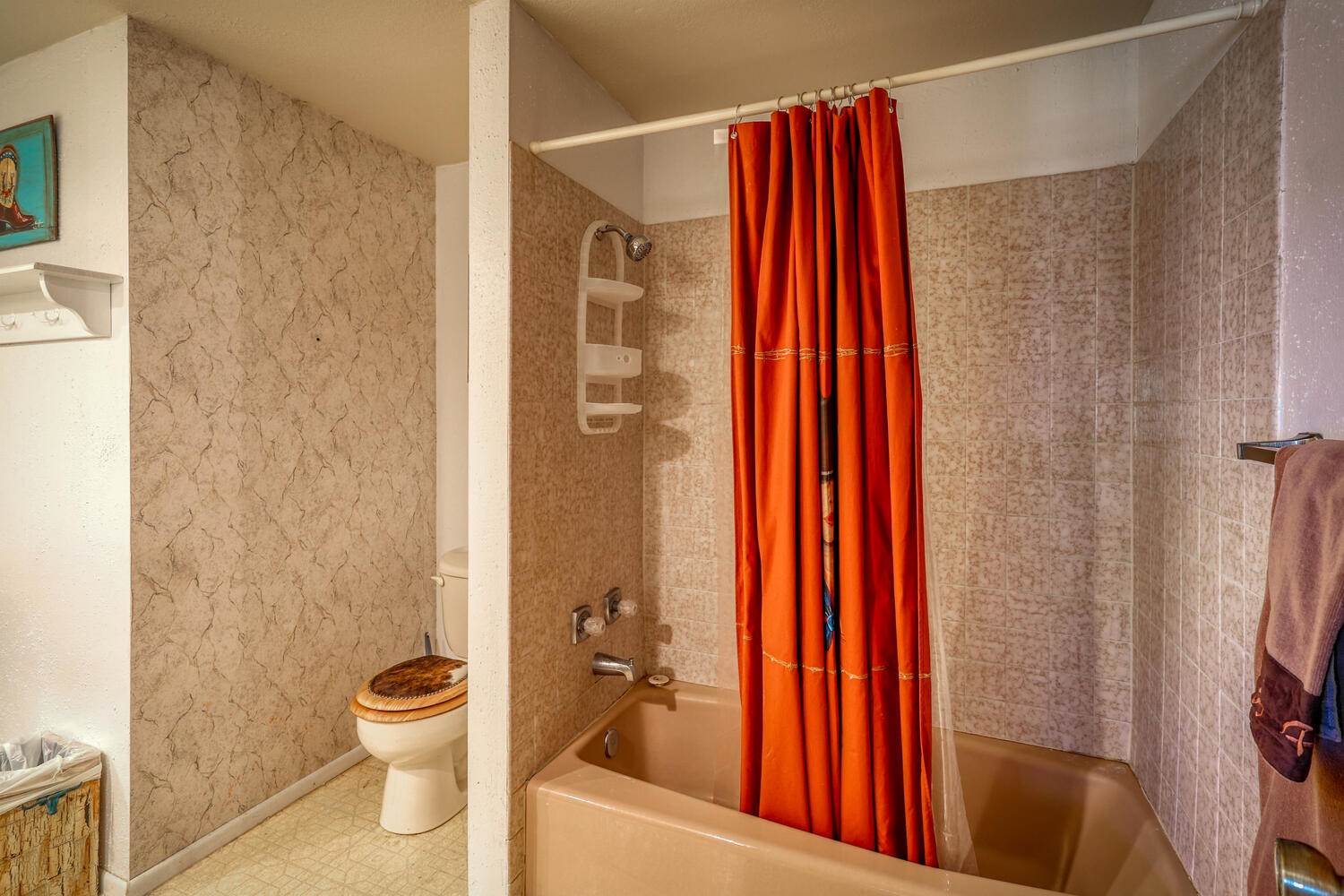 A bathroom with an orange shower curtain.