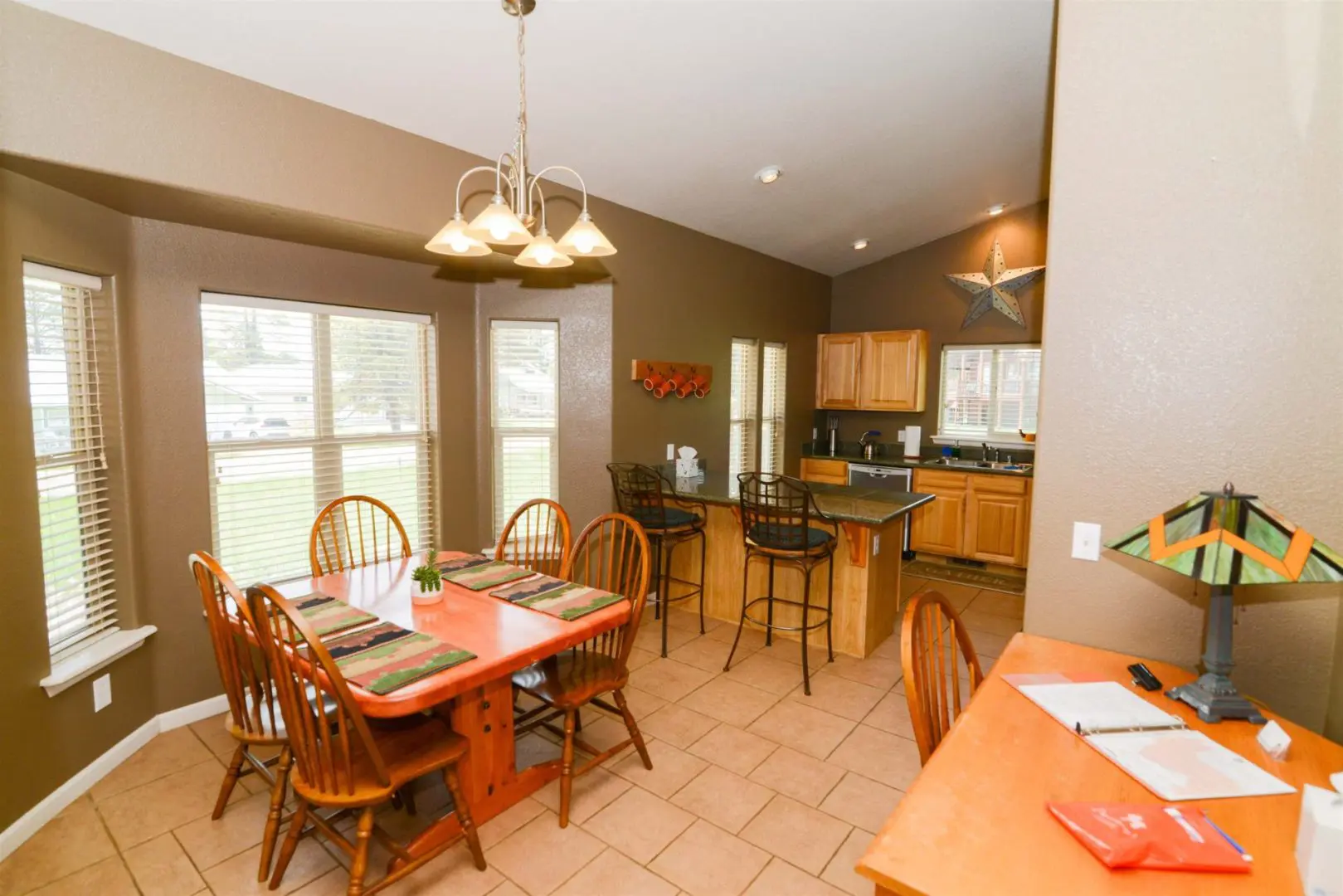 A kitchen with a dining table and chairs.