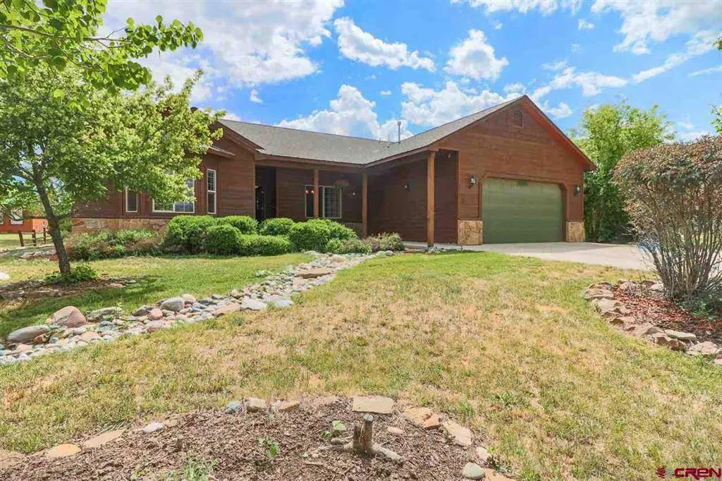 A home with a driveway and grass in the front yard.