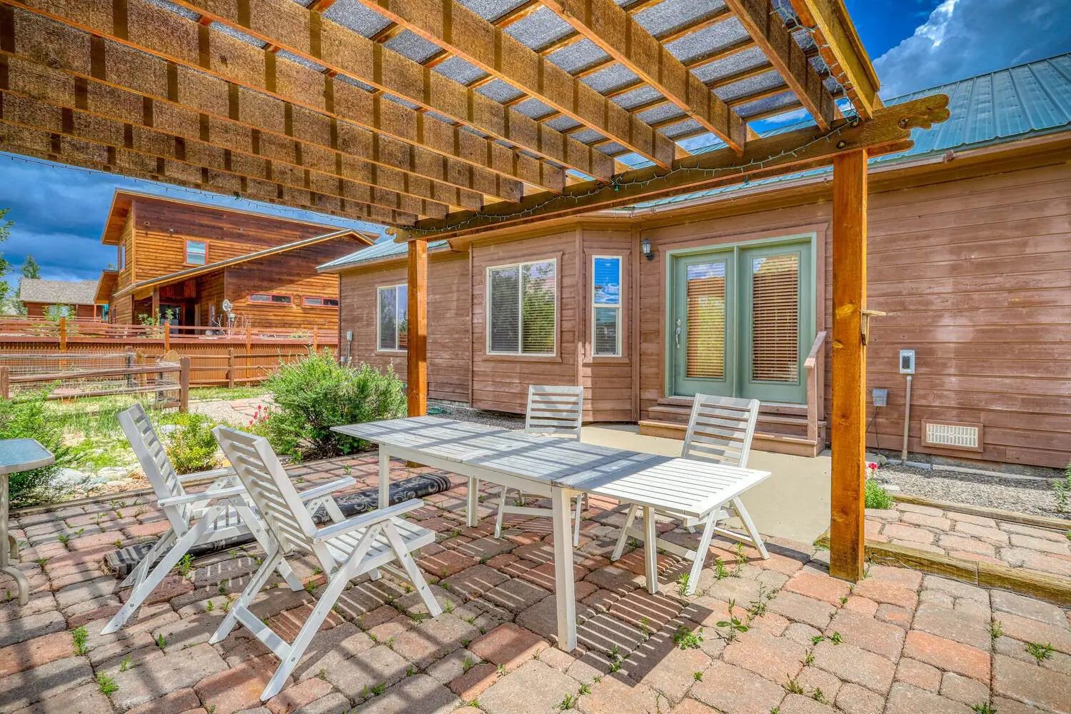 A patio with a table and chairs in front of a house.