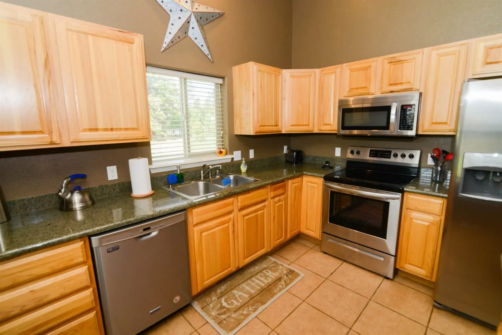 A kitchen with stainless steel appliances and wood cabinets.