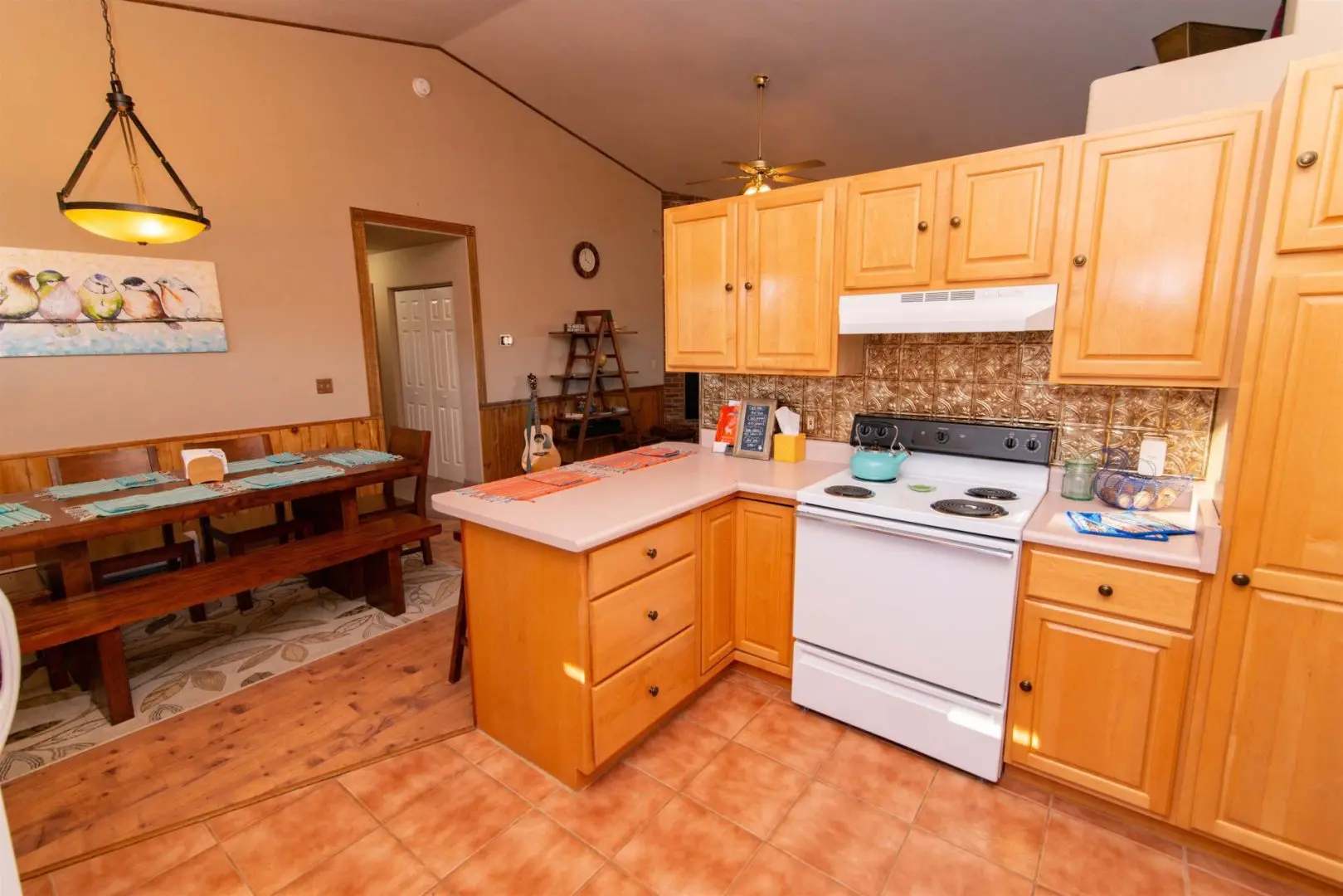 A kitchen with wooden cabinets and a table and chairs.