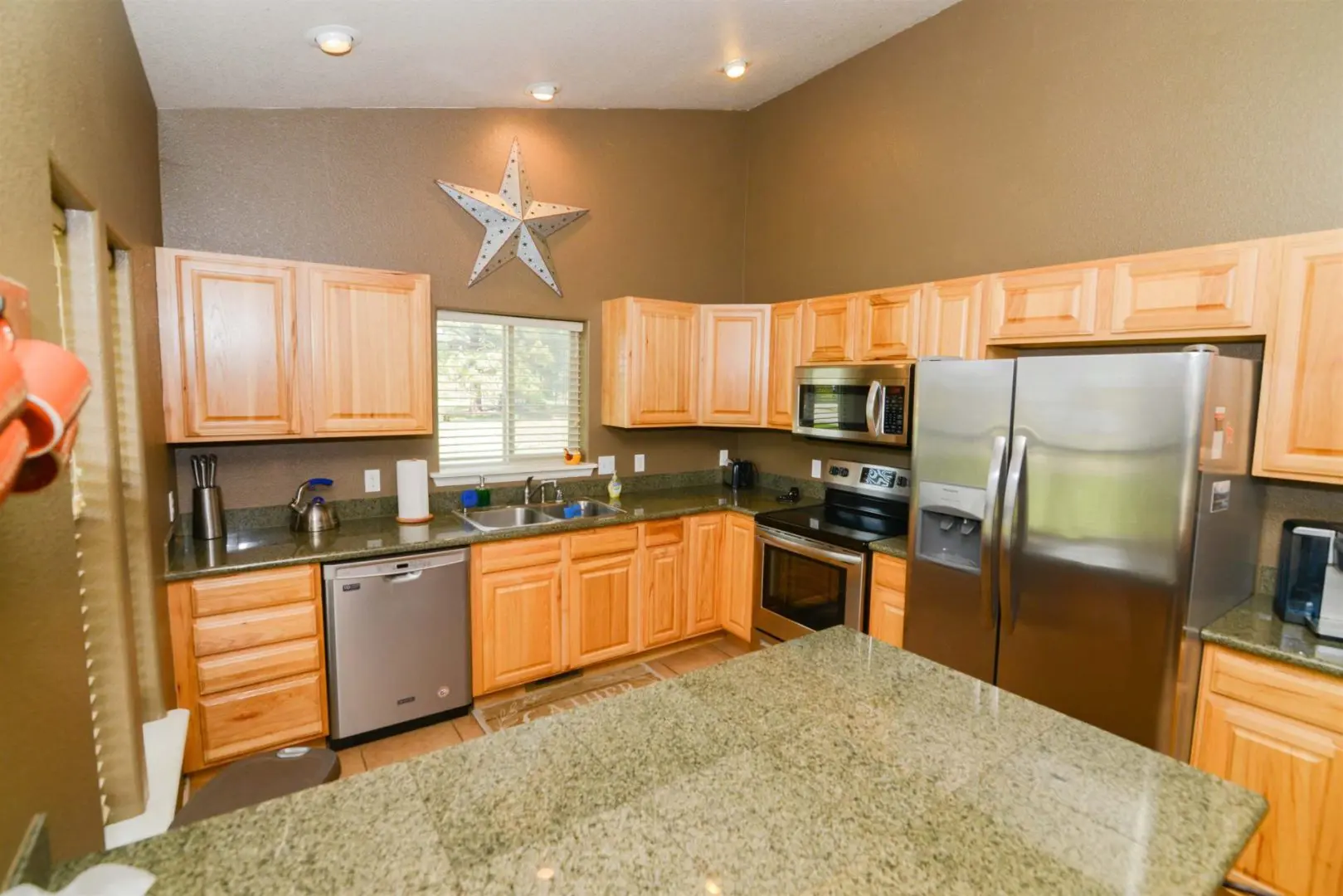 A kitchen with granite counter tops and stainless steel appliances.