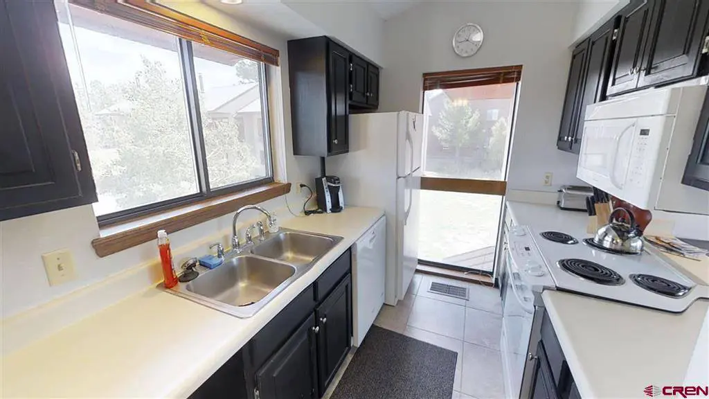 A kitchen with black cabinets and a sink.