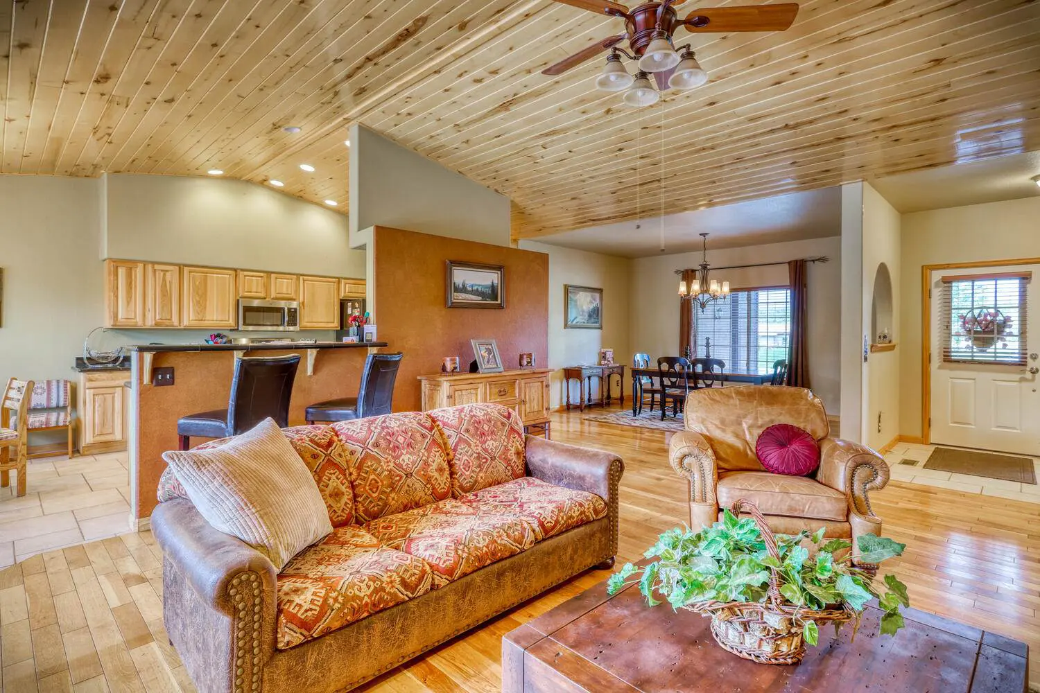 A living room with wood ceilings and wooden furniture.