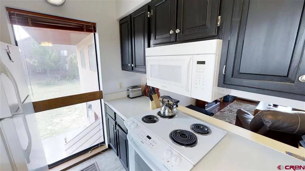 A kitchen with a stove and microwave.