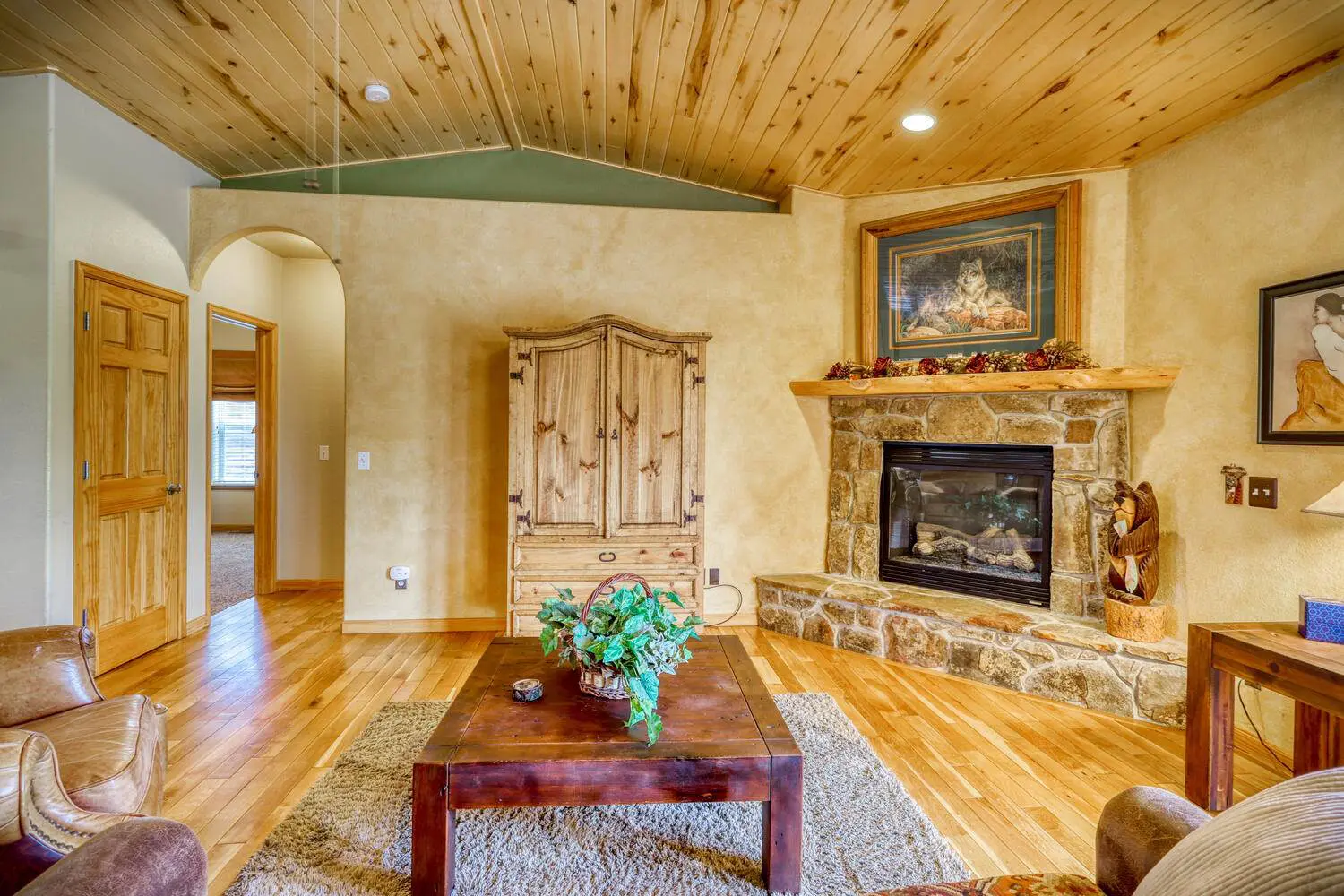 A living room with wood floors and a fireplace.