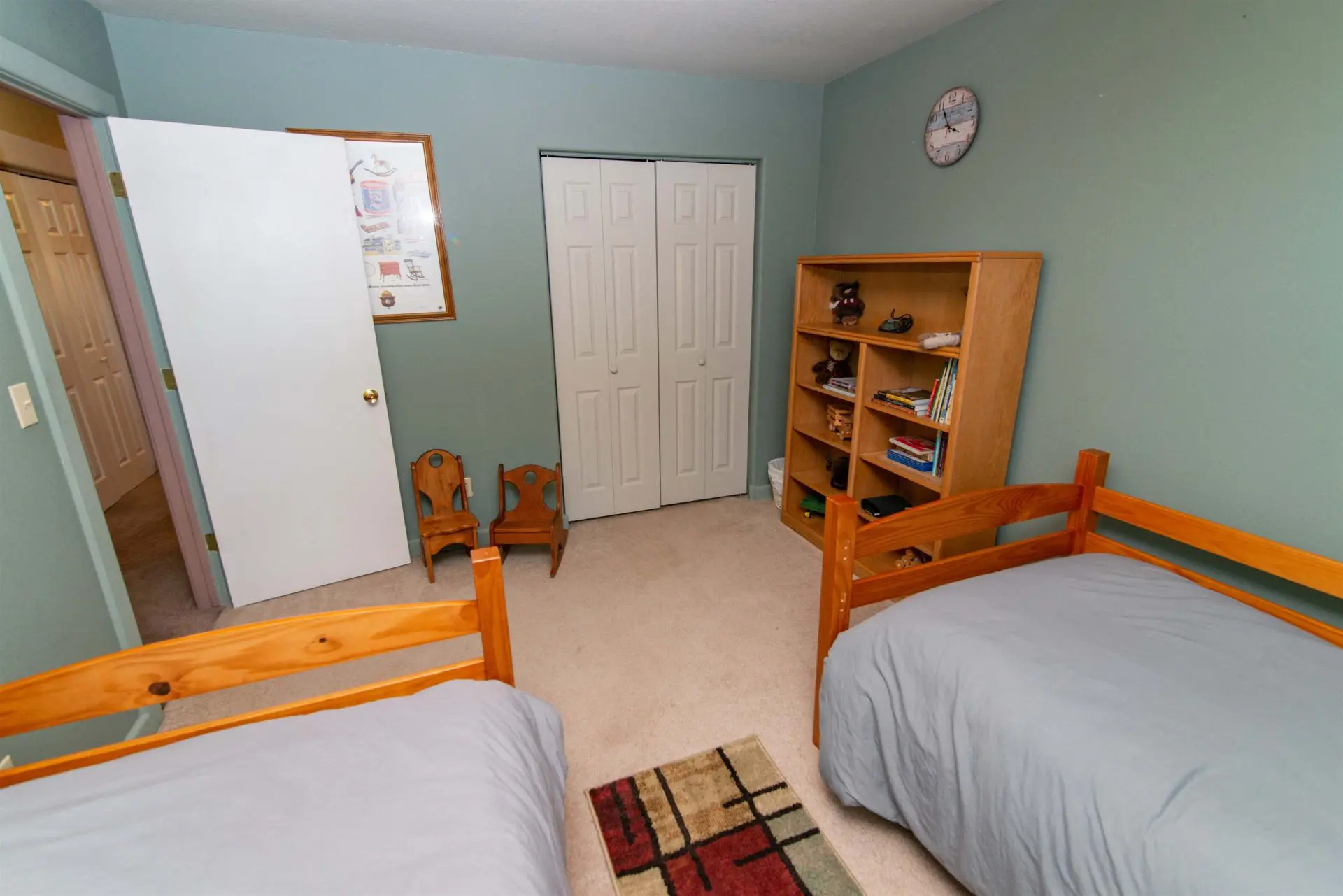 A bedroom with two beds and a dresser.