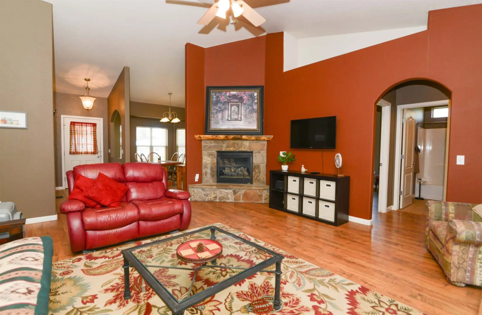 A living room with red walls and a fireplace.