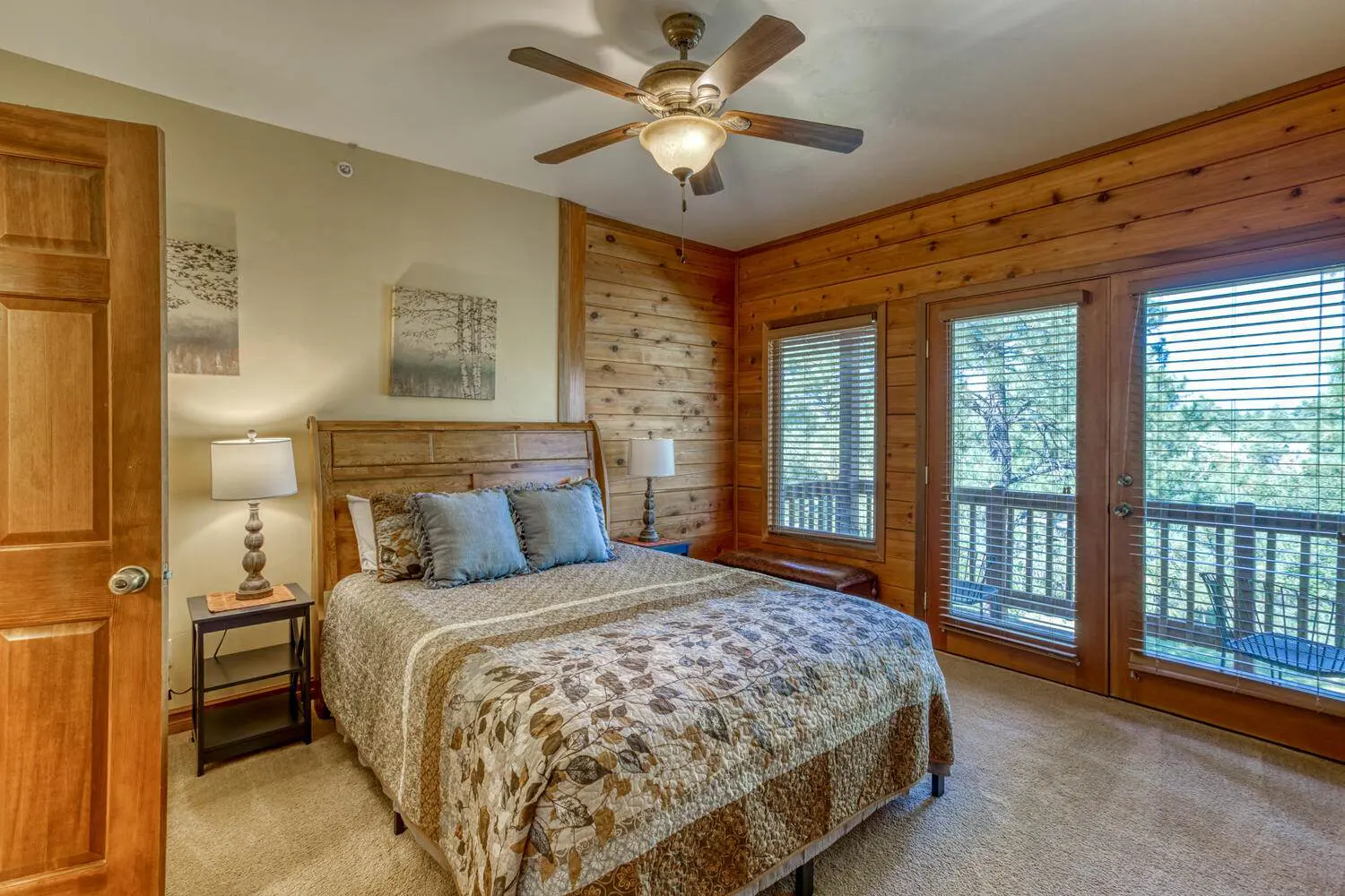 A bedroom with wood paneling and a ceiling fan.