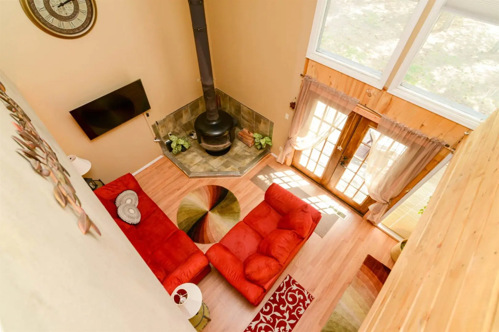 An aerial view of a living room with red couches and a fireplace.