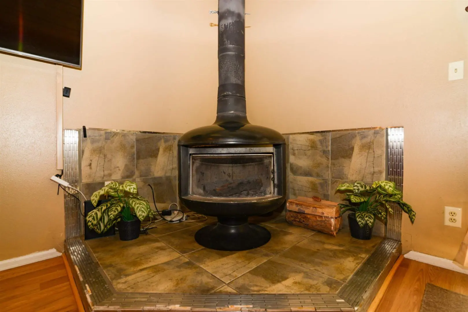 A wood burning stove in a room with a tv.